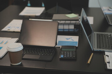 Laptop on a desk in an open financial office.