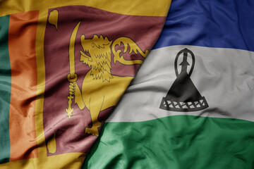 big waving national colorful flag of lesotho and national flag of sri lanka .