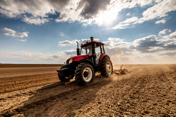 Agriculture machinery in action, a tractor plows a field on a bright day