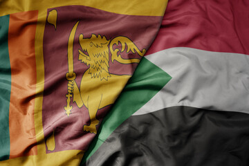 big waving national colorful flag of sudan and national flag of sri lanka .