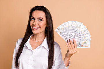 Portrait of elegant pretty wealthy girl hold dollar bills look empty space brainstorm isolated on...