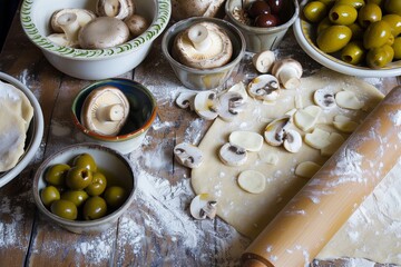 Fototapeta na wymiar fresh dough with a rolling pin and bowls of mushrooms and olives nearby