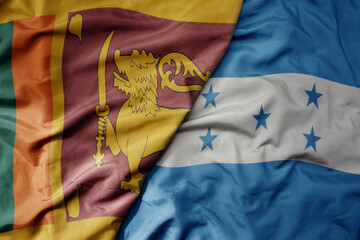 big waving national colorful flag of honduras and national flag of sri lanka .