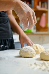 baker kneading dough on table