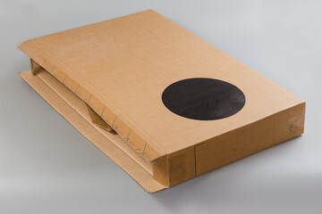 Rectangular flat kraft cardboard packing box lying on its side