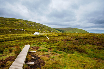 Idyllic view in Glendalough Valley, County Wicklow, Ireland. Mountains, lake and tourists walking...