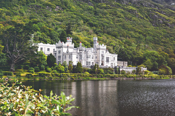 Fototapeta na wymiar Kylemore Abbey with water reflections in Connemara, County Galway, Ireland, Europe. Benedictine monastery founded 1920 on the grounds of Kylemore Castle. Mainistir na Coille Moire
