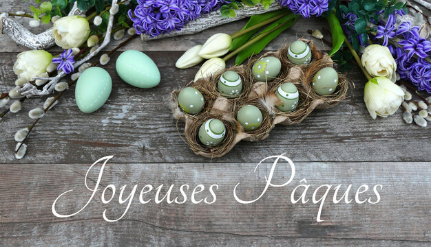 Bouquet de fleurs avec &oelig;ufs de P&acirc;ques sur planche de bois minable avec le texte Joyeuses P&acirc;ques.	