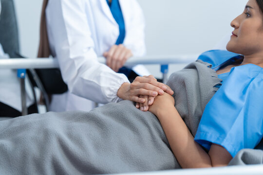 Two conficent doctor or specialist of kidney cancer talking together with female mix race patient on bed at medical ward, checkup, recovering after successful surgery concept.