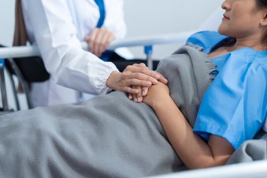 Two conficent doctor or specialist of kidney cancer talking together with female mix race patient on bed at medical ward, checkup, recovering after successful surgery concept.