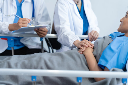 Two conficent doctor or specialist of kidney cancer talking together with female mix race patient on bed at medical ward, checkup, recovering after successful surgery concept.