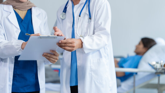 Two conficent doctor or specialist of kidney cancer talking together with female mix race patient on bed at medical ward, checkup, recovering after successful surgery concept.
