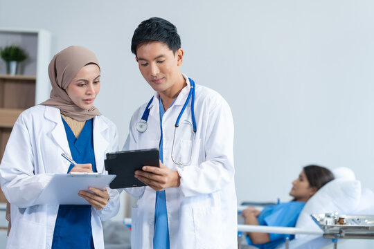 Two conficent doctor or specialist of kidney cancer talking together with female mix race patient on bed at medical ward, checkup, recovering after successful surgery concept.