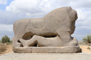 Several perspectives of the Lion of Babylon statue in the ancient city of Babylon on a cloudy day