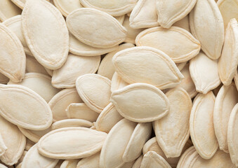 Raw white salted pumpkin seeds top view macro background.Healthy snack.
