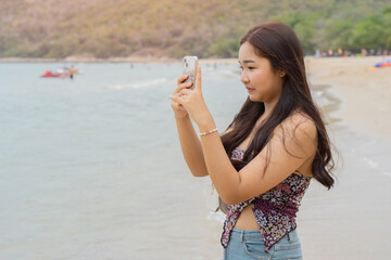Young woman take a picture by her smartphone and updating her social network status