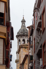 Detail shot of the bell tower of the church of Santa María de la Asunción in the tourist coastal town of Bermeo on a cloudy day.