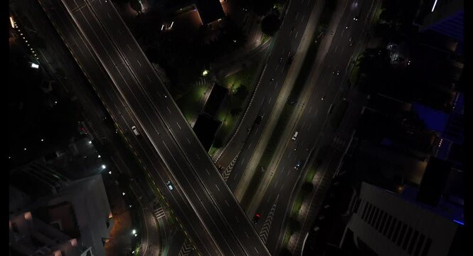 Top down aerial view of traffic on the main road passing Jakarta's  road at night.