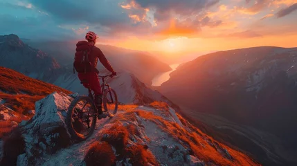 Abwaschbare Fototapete A man is riding a bike on the top of a mountain. He is navigating the rocky terrain with skill and determination, enjoying the challenge and the breathtaking views around him © lublubachka