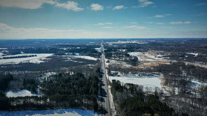 Aerial view of a road framed by trees in a winter landscape