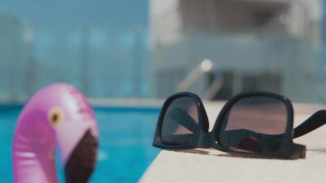 Sunglasses beach summer vacation background. Beach pool equipment with travel sunglasses on yellow holiday towel. Tropical vacation concept.