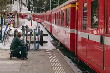Morteratsch, Switzerland - March 2024: Famous Bernina red train crossing the Alps