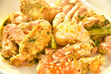 stir fried swimmer crab in yellow curry and egg on plate 