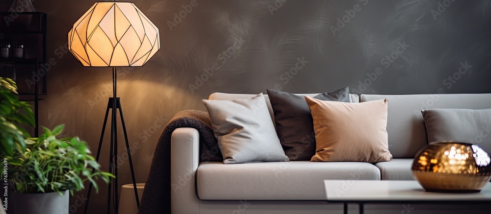 Poster an intimate view of a sofa adorned with soft pillows and a luminous table lamp nearby