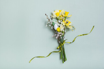 Easter spring bouquet with daffodils and willow on green background. Easter greeting card