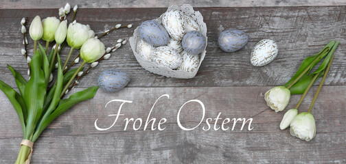 Frohe Ostern-Grußkarte: Nest mit  Ostereiern, Blumen und Frohe Ostern-Inschrift.