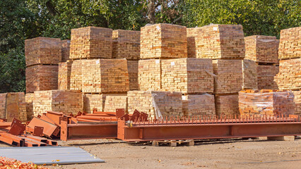 Pallets of Yellow Bricks Steel Beams at Construction Site
