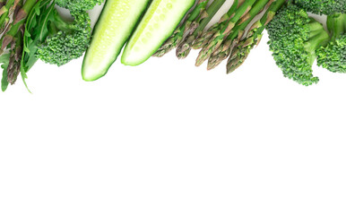Frame of green vegetables broccoli, arugula, cucumber, asparagus and garlic on white background