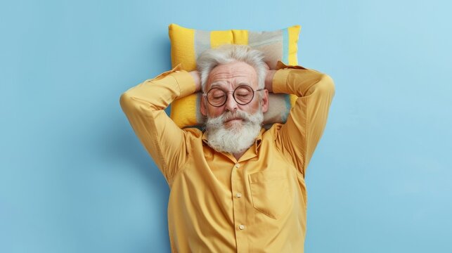Elderly man sleeping on pillow isolated on pastel blue colored background Sleep deeply peacefully rest. Top above high angle view photo portrait of satisfied .senior wear yellow shirt