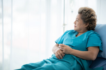 Fototapeta premium A woman in a blue hospital gown is laying in bed