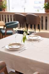 Vertical high angle view no people shot of minimalistic table set design in modern restaurant