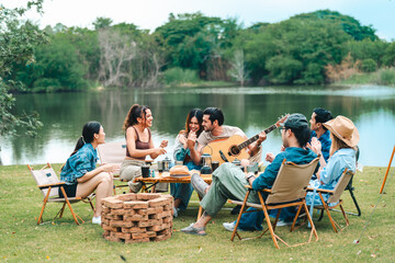 Young friends share a fun summer weekend outdoors with a campfire, bar-b-q, and picnic, celebrating vacation, friendship, and happy moments together.