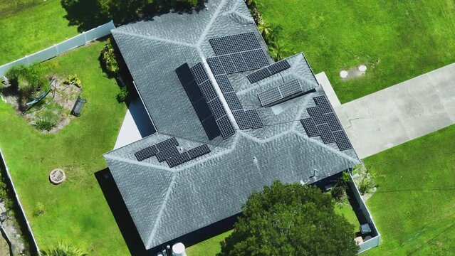 American building roof with rows of blue solar photovoltaic panels for producing clean ecological electric energy. Renewable electricity with zero emission concept
