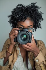 Black woman holding a camera, world photography day concept.