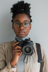 Black woman holding a camera, world photography day concept.