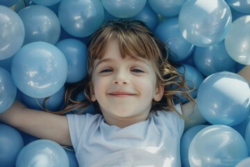 Child playing in a children's ball pit, concept of children's day and fun. - obrazy, fototapety, plakaty