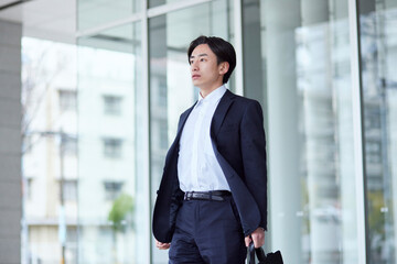 オフィスビルとスーツを着た若い日本人ビジネスマン
