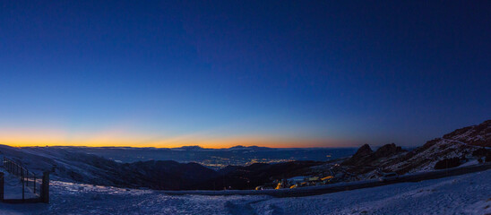 Panoramic view at the city of Granada during evening twilight after sunset seen from Sierra Nevada mountains, Andalusia, Spain