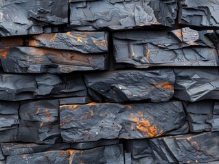 A wall made of black rocks with some orange spots