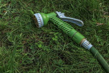 A gun for watering plants in the garden with a hose