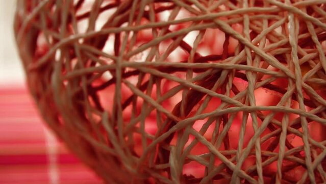 The red woven decorative heart rotates on its own axis.