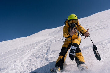 Fototapeta na wymiar Woman snowboarder riding and taking photo on mobile phone on slope of powdery snow in high mountains. Freeride at ski resort