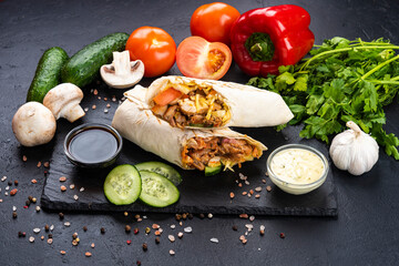 Shawarma with vegetables and meat on a black background
