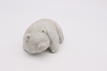 An image of a porcelain toy in the shape of a bear on a light background.