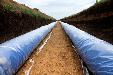 Construction of a water conduct. A double thread of large diameter water pipe is laid through plain...