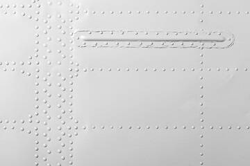 White industrial metal wall with rivets pattern, front view